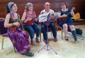 Jade Flahive-Gilbert, Mary Flahive, Neil ? and Carol ? in a ukulele emsemble
